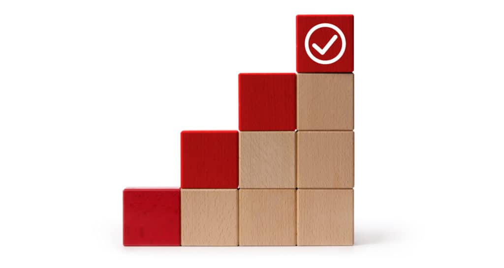 ascending cube blocks stacked, with the top cube coloured red for each stack. There is a checkmark on the tallest stack.